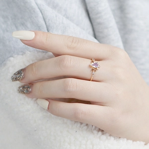 Detailed view of pear-cut opal ring in gold finish worn on finger for an elegant style