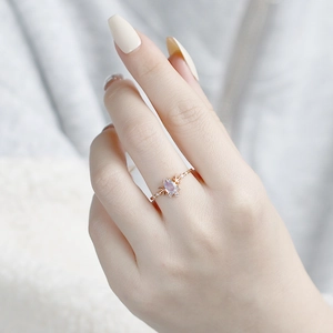 Close-up of rose gold teardrop opal ring with celestial moon and star accents