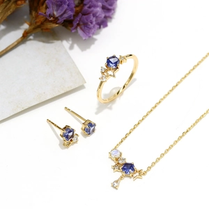 Dettaglio del set di gioielli placcati oro s925 con pietre blu esagonali e stelle