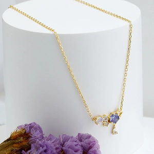 Dettaglio della collana a stella e luna con gemme viola e placcatura in oro