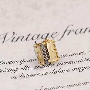 Detail of a vintage locket shaped like an open book with inlaid colorful gemstones