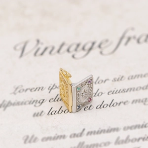 Macro shot of vintage locket book pendant with colorful gems and gold silver accents
