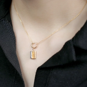 Detail of vintage style gold pendant with yellow gemstone and colorful crystal inlay