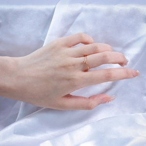 Detail van een minimalistische 925 zilveren vergulde ring met V-vorm op wit zijden stof