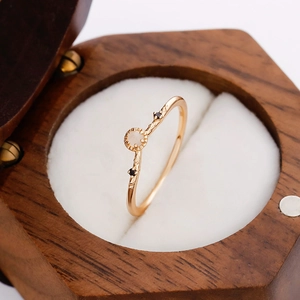 Close-up van een maansteen ring met zwarte stenen op een gouden takvormige ringband