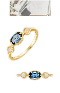 Vue détaillée d'une bague en or 10K avec topaze bleue de Londres et opales irisées latérales