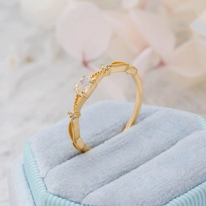 Macro view of a delicate gold-plated silver ring with natural moonstone in a blue box