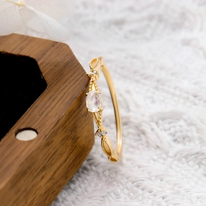 Detail of vintage gold ring with moonstone and delicate filigree on a wooden box