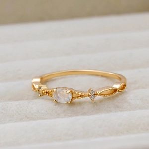 Detail shot of a slim gold plated S925 ring with oval moonstone and beaded accents