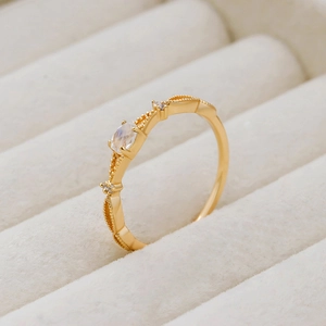 Detailed close-up of pear-shaped moonstone gold ring with decorative milgrain edge