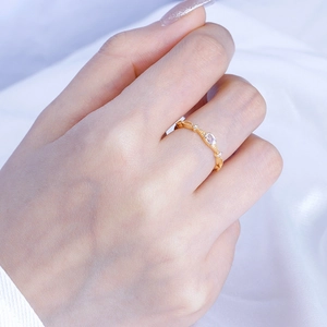 Close-up of S925 silver gold-plated ring with moonstone on hand and silk background