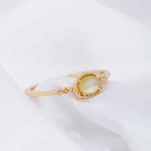 Elegante anillo vintage de plata S925 con cristal amarillo sobre fondo de seda blanca