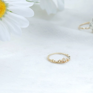 Makroaufnahme eines goldenen S925 Silberrings in Kronenform mit filigranen Blumenschnitzereien