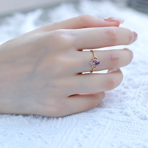 Close-up of vintage gold crown ring with purple amethyst stone on lace background