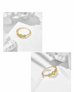 Macro detail of gold-plated silver ring with square green gemstone and pink flowers