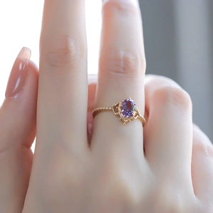 Detail of luxury crown bubble ring featuring purple amethyst and gold twisted band