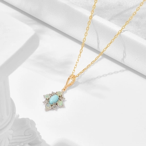 Detail of floral S925 silver gold-plated pendant with turquoise and opal stones