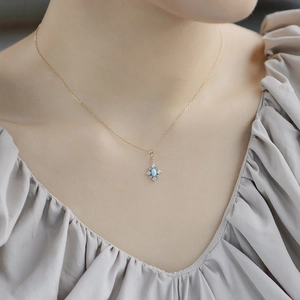 Detail of vintage S925 gold necklace featuring a blue turquoise pendant on model neck