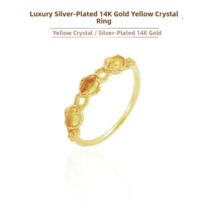 Macro detail of three oval yellow citrine gemstones set in 14K gold-plated silver band