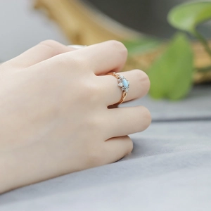Macro detail of vintage floral ring with turquoise stone and opal petals on hand