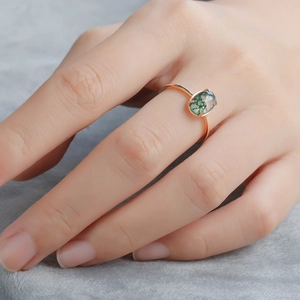 Macro detail of oval moss agate ring in gold plated S925 silver setting on hand