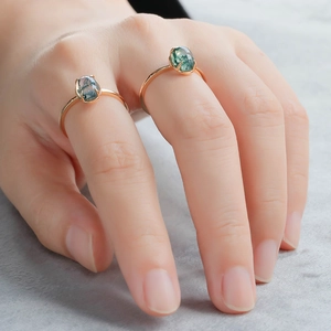 Detail of two moss agate rings in rose gold finish worn on fingers for a stylish look