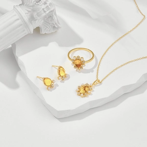 Luxuriöses Schmuckset mit Bernstein Blumenanhänger Ohrringen und Ring auf Stein