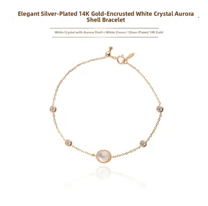 Detail view of 14K gold plated silver bracelet with aurora shell and white crystal