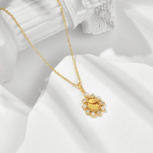 Detaillierte Nahaufnahme eines Vintage-Blumenanhängers mit Perlen und Kristallen in 14K Gold