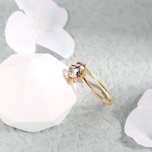 Primer plano de anillo de cuarzo dorado con inclusiones negras y grabados vintage