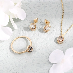 Detalle macro de un conjunto de joyas de cuarzo rutilado dorado con detalles de circón