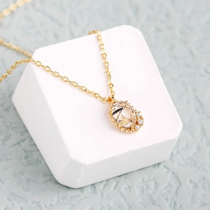 Detalle de un collar de oro con cuarzo rutilado óvalo y adornos de circonitas