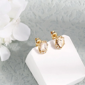 Detalle de pendientes de oro con cuarzo rutilado natural y microcristales engastados