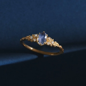 Close-up of vintage gold vine ring with oval blue iolite and side diamond clusters