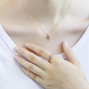 Elegant gold necklace and ring set with purple gemstone and leaf vine accents