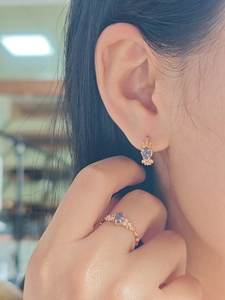 Close-up of elegant rose gold jewelry set with oval purple stones and sparkling crystals