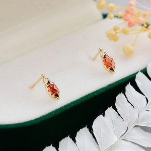 Detalle de pendientes en oro de 14K con granate de talla marquesa y engaste vintage