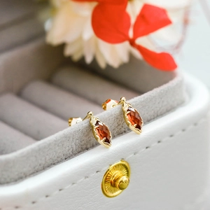 Detalle de pendientes de plata S925 bañados en oro 14K con granate de talla marquesa