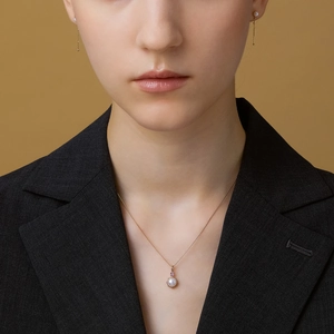 Dettaglio della collana di perle e orecchini lunghi con ametista sulla modella