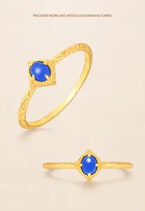 Macro shot of vintage gold-plated ring with blue oval gemstone and lace edge details
