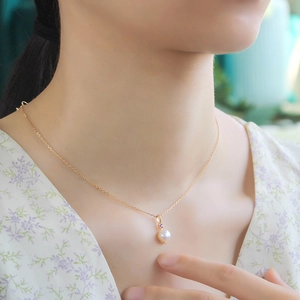 Dettaglio di una collana con ametista e perla su una raffinata catena in argento dorato 14K