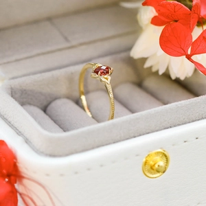 Macro de un anillo de oro de 14K con granate de corte marquesa y diamantes laterales