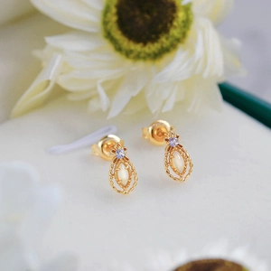 Detail of vintage 14K gold-plated opal earrings with marquise stones and purple accents