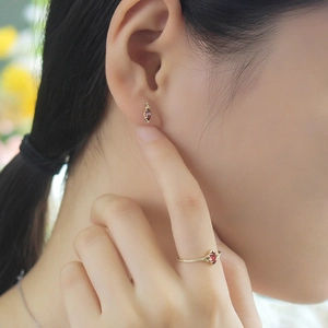 Detalle del conjunto de anillo y pendientes de granate vintage bañados en oro 14K