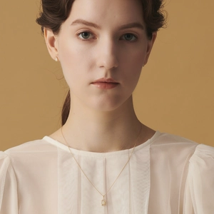 Detail of 14K gold plated silver necklace with opal pendant on elegant model