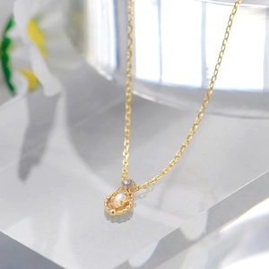 Detailed close-up of a 14K gold plated necklace with a retro opal pendant on a display