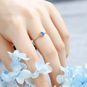 Detailed close-up of a gold S925 silver ring with blue gemstone and carved texture