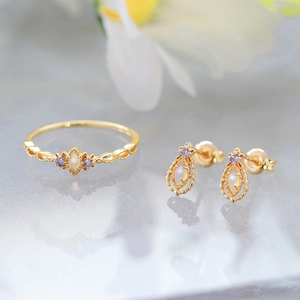 Detail of retro jewelry set with marquise opal and purple stones in gold finish