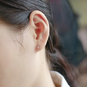 Close-up of elegant teardrop opal earrings in 14K gold plated silver on a model
