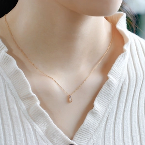Close-up of a vintage pear-shaped opal pendant on a 14K gold-plated chain
